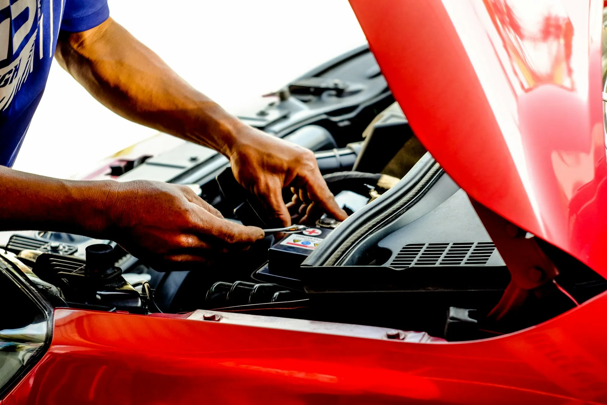 Technician with sleeves rolled up working in an engine bay
