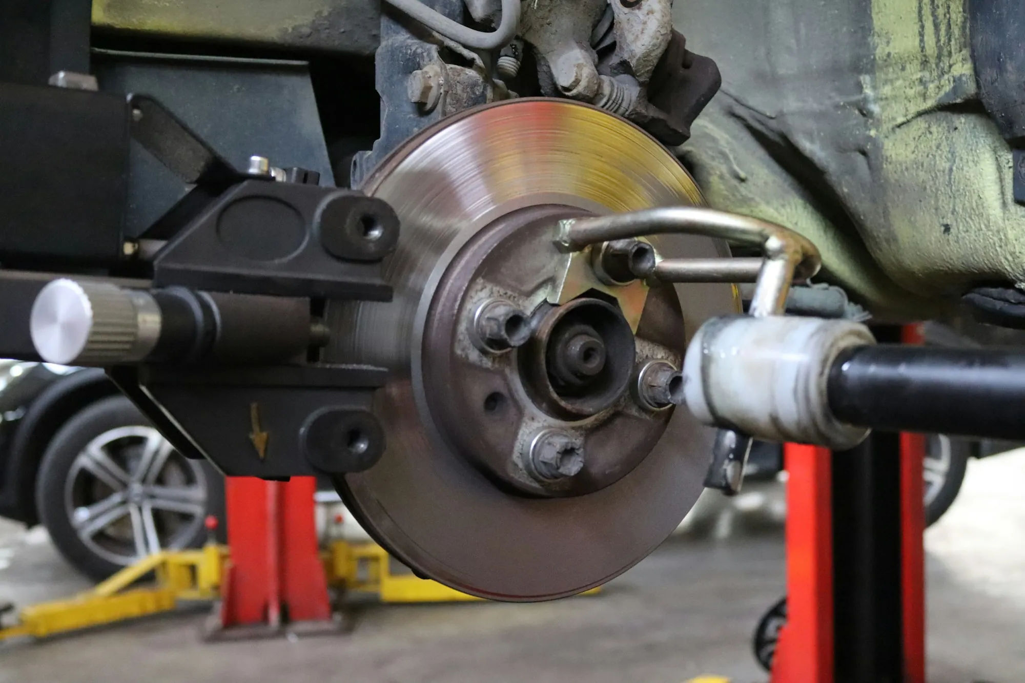 Brake rotor and caliper on a car raised on a red lift